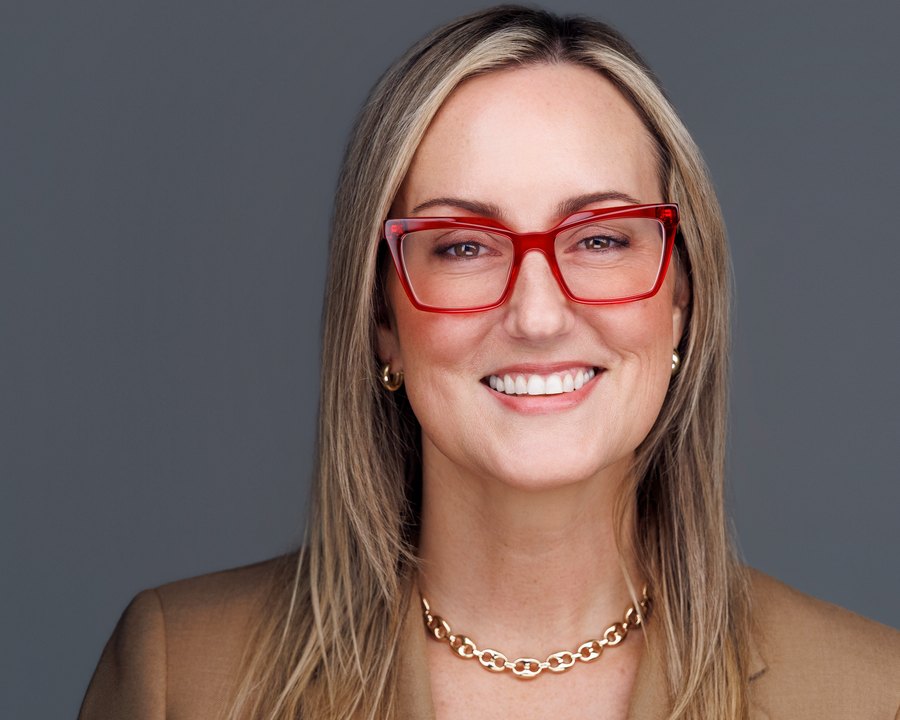 Professional headshot with a warm, confident smile